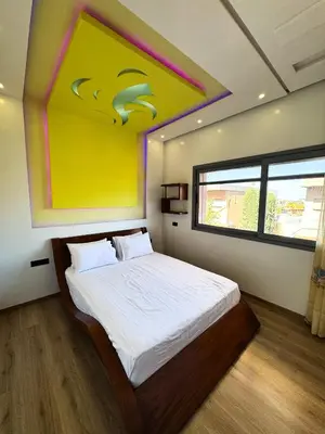 a bedroom with a bed with a painting on the wall at Villa de luxe, à 20 minutes de Jamaa El Fna in Marrakech