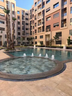 a fountain in the middle of a courtyard with buildings at Séjour Premium - Piscine, Jacuzzi, Chauffé et Salle de sport in Marrakech