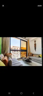a living room with a couch and a large window at Appartemment Luxe Gueliz in Marrakech