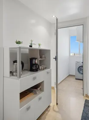 a kitchen with white shelves and a door to a laundry room at Modern apartment, swimming pool and sports in Marrakech
