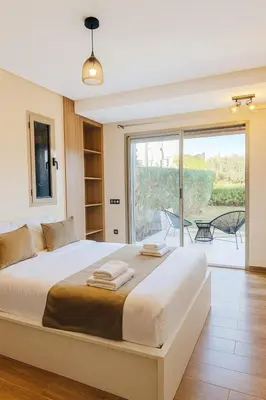 a bedroom with a large bed and a large window at Spacious Ground Floor Oasis with Pool & Golf Course View 1rom in Marrakech