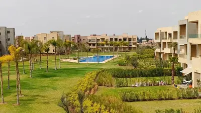 a view of a park with a swimming pool and buildings at Spacious Ground Floor Oasis with Pool & Golf Course View 1rom in Marrakech