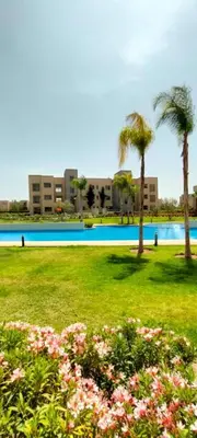 a park with a pool and palm trees and flowers at Spacious Ground Floor Oasis with Pool & Golf Course View 1rom in Marrakech