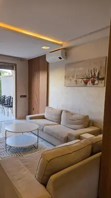 a living room with a couch and a table at Spacious Ground Floor Oasis with Pool & Golf Course View 1rom in Marrakech