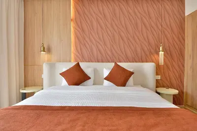 a bedroom with a large white bed with orange pillows at Noria Residence - Premium 2BR Apartment with Pool View in Marrakech