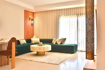 a living room with a green couch and a table at Noria Residence - Premium 2BR Apartment with Pool View in Marrakech