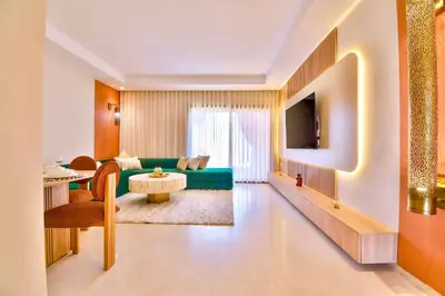 a living room with a green couch and a table at Noria Residence - Premium 2BR Apartment with Pool View in Marrakech