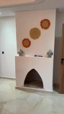 a white fireplace with decorations on the wall at appartement Marrakech in Marrakech