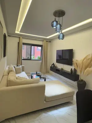 a living room with a couch and a flat screen tv at Élégant Appartement avec Suite à 10 min du centre in Marrakech