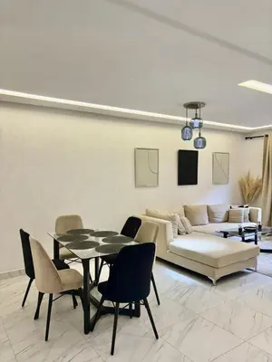 a living room with a couch and a table and chairs at Élégant Appartement avec Suite à 10 min du centre in Marrakech
