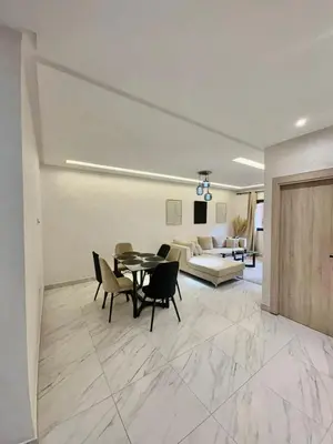 a living room with a table and chairs and a couch at Élégant Appartement avec Suite à 10 min du centre in Marrakech