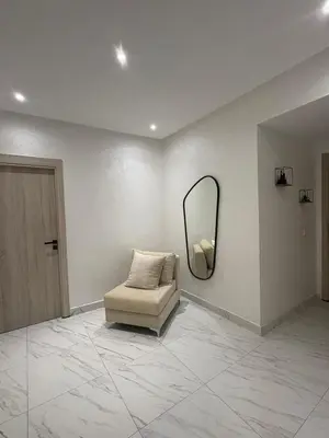 a white room with a chair and a mirror at Élégant Appartement avec Suite à 10 min du centre in Marrakech