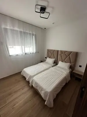 a bedroom with a large bed with white sheets and a window at Appartement cosy à Marrakech in Marrakech