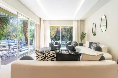 a living room with two couches and a large window at Luxurious villa Marrakech La Palmeraie in Marrakech