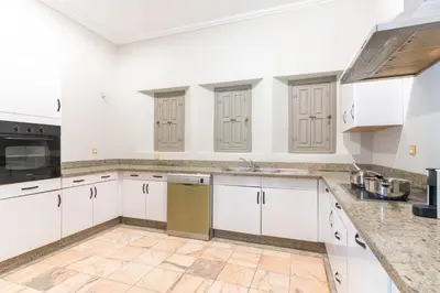 an empty kitchen with white cabinets and appliances at Luxurious villa Marrakech La Palmeraie in Marrakech