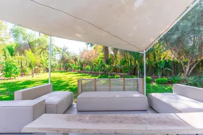 a group of white couches under a large tent at Luxurious villa Marrakech La Palmeraie in Marrakech