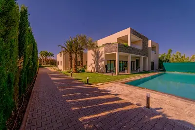 a villa with a swimming pool and a house at Villa Lumeria in Marrakech