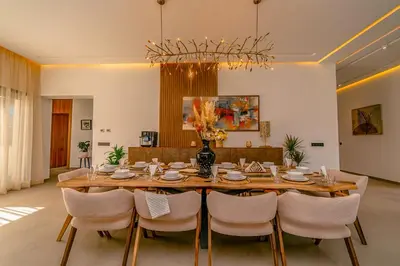 a dining room with a large wooden table and chairs at Villa Lumeria in Marrakech