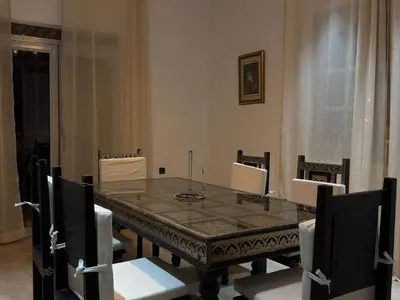 a dining room with a table and white chairs at Charmante villa avec piscine privée et jardin in Marrakech