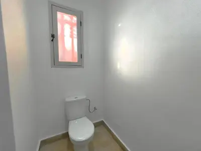 a white bathroom with a toilet and a window at Charmante villa avec piscine privée et jardin in Marrakech
