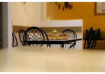 a dining room table with two chairs and a clock on it at Luxury Riad Marrakech - 3BR - Rooftop - Jacuzzi in Marrakech