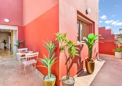a patio with a table and potted plants at Appartement Chic & Neuf à Guéliz - Terrasse et Parking in Marrakech