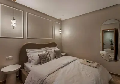 a bedroom with a large bed and a mirror at Appartement Chic & Neuf à Guéliz - Terrasse et Parking in Marrakech