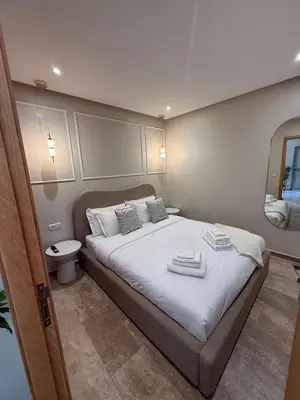 a bedroom with a bed with towels on it at Appartement Chic & Neuf à Guéliz - Terrasse et Parking in Marrakech
