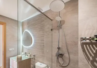 a bathroom with a shower with a toilet and a sink at Appartement Chic & Neuf à Guéliz - Terrasse et Parking in Marrakech