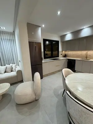 a living room with a kitchen and a table and chairs at Refined Apartment in Guéliz Laya Home Luxury in Marrakech