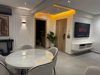 a dining room with a table and a tv at Refined Apartment in Guéliz Laya Home Luxury in Marrakech