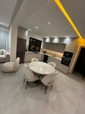 a kitchen and living room with a table and chairs at Refined Apartment in Guéliz Laya Home Luxury in Marrakech