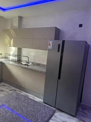 a kitchen with a stainless steel refrigerator in a room at Appartement Abdessamad Hébergement réservé aux familles in El Gouassem
