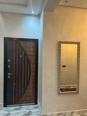 a mirror on a wall next to a door at Appartement Abdessamad Hébergement réservé aux familles in El Gouassem