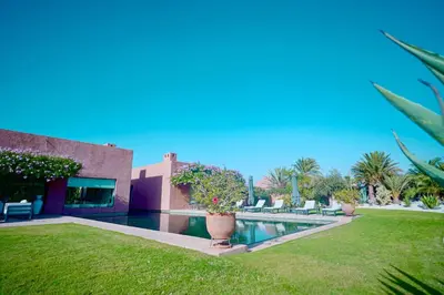 a house with a swimming pool next to a yard at Royal Palm Luxury Villa Heated Pool Spa in Moussiha