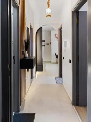 a hallway with white floors and black doors at Cozy Apt Close to Gueliz & Medina in Marrakech