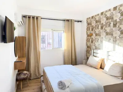 a bedroom with a bed and a window at Cozy Apt Close to Gueliz & Medina in Marrakech