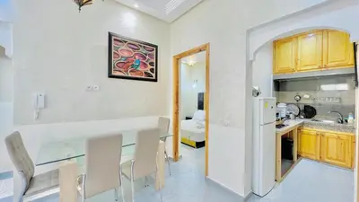 a kitchen with a table and chairs in a room at Cycas family apart ground floor parking in Marrakech