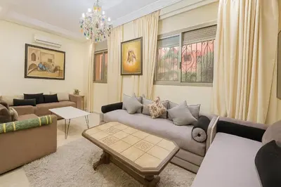 a living room with a couch and a table at Cycas family apart ground floor parking in Marrakech