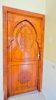 a wooden door with a design on it at Cycas family apart ground floor parking in Marrakech