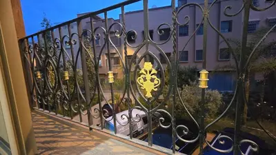 a wrought iron fence in front of a building at Cycas Family Apart grand wifi parking in Marrakech