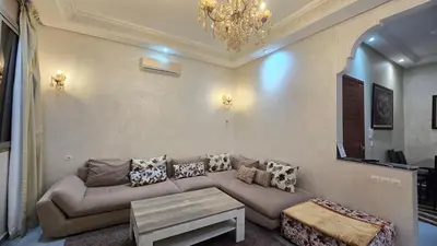 a living room with a couch and a chandelier at Cycas Family Apart grand wifi parking in Marrakech