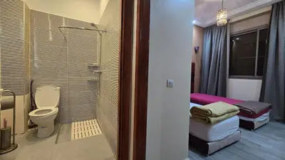 a bathroom with a shower and a toilet in a room at Cycas Family Apart grand wifi parking in Marrakech