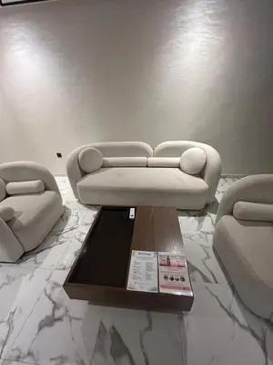 a living room with a white couch and a table at Palmeraie Gates 2 chambres Piscine et Parking in Marrakech
