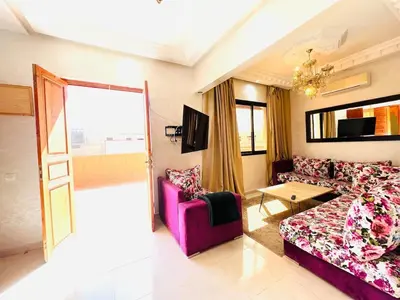 a living room with a couch and a table at Cycas Family aparts 1 ch salon parking in Marrakech