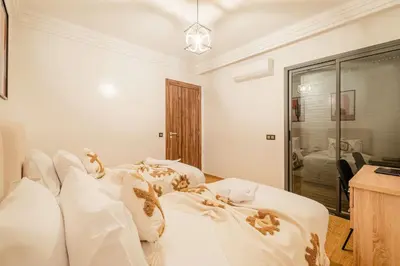 a bedroom with a bed with white sheets and pillows at New! Modern 2BR Guéliz Center, Station & M-Avenue in Marrakech