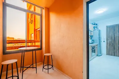 a kitchen with a table and two stools in a room at New! Modern 2BR Guéliz Center, Station & M-Avenue in Marrakech