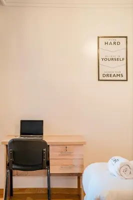 a desk with a laptop and a chair next to a bed at New! Modern 2BR Guéliz Center, Station & M-Avenue in Marrakech