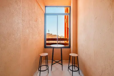 a table and two stools in front of a window at New! Modern 2BR Guéliz Center, Station & M-Avenue in Marrakech