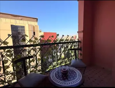 a balcony with a table and chairs and a fence at Maison LINA in Marrakech